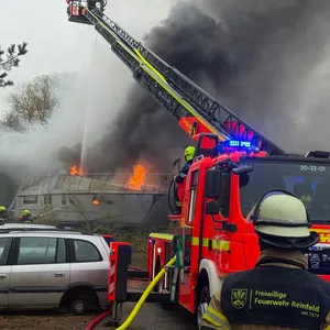 Feuerwehrkräfte löschen eine brennende Jacht.