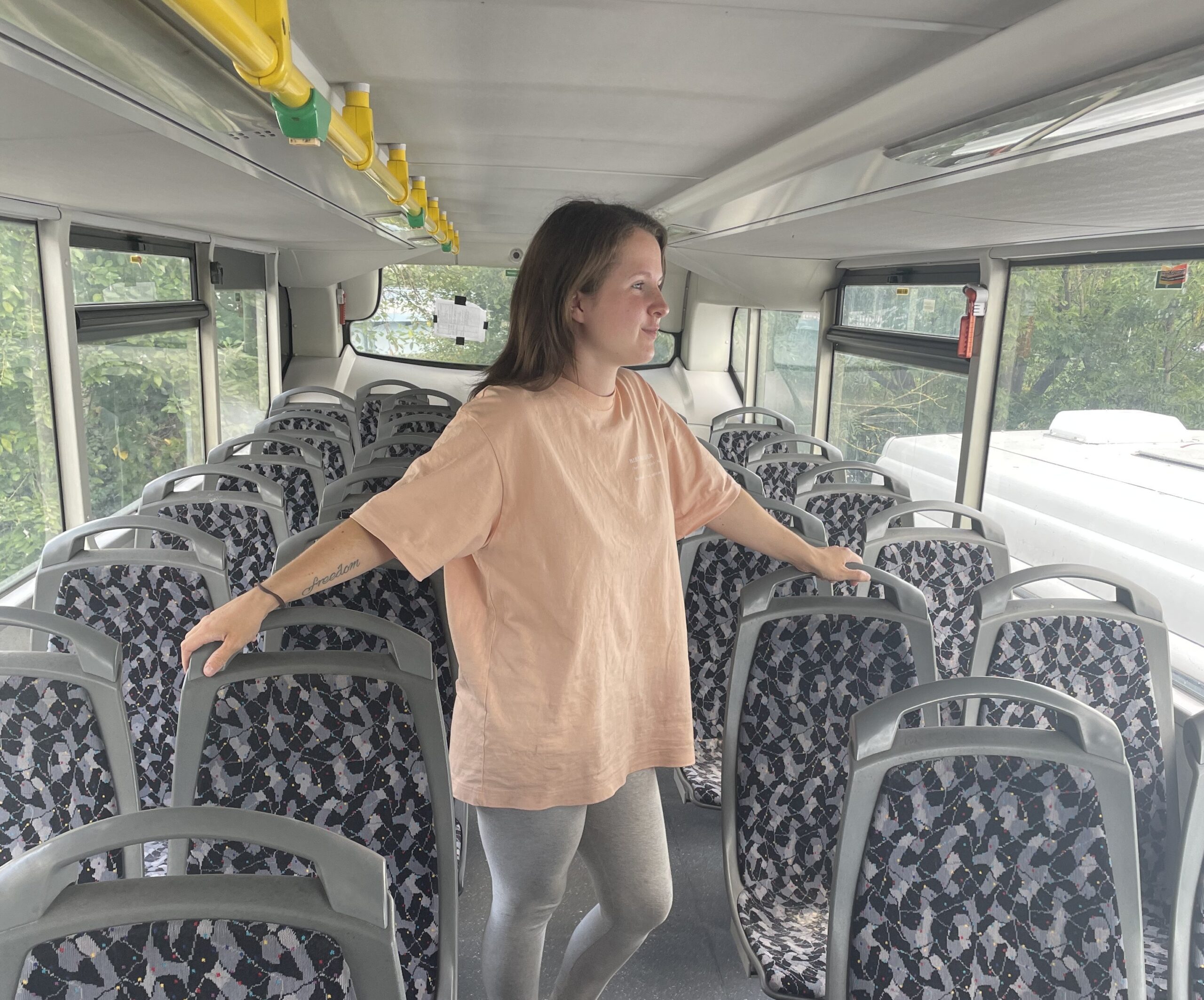 Flo Eckhoff steht in der zweiten Etage des Doppeldeckerbusses zwischen den Sitzen.