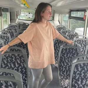 Flo Eckhoff steht in der zweiten Etage des Doppeldeckerbusses zwischen den Sitzen.