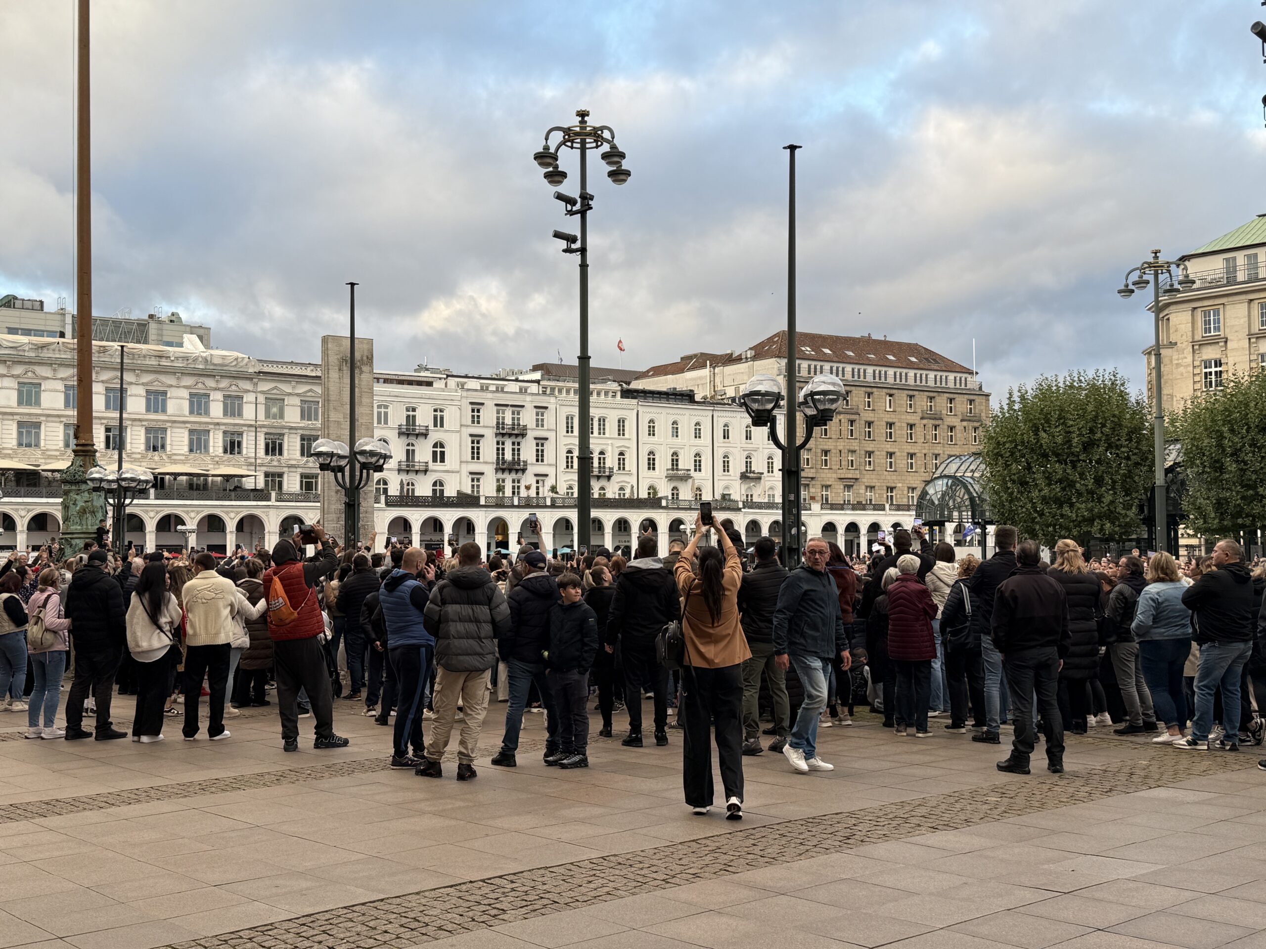 Menschen gedenken auf dem Hamburger Rathausmark dem bosnischen Sänger Halid Bešlić.