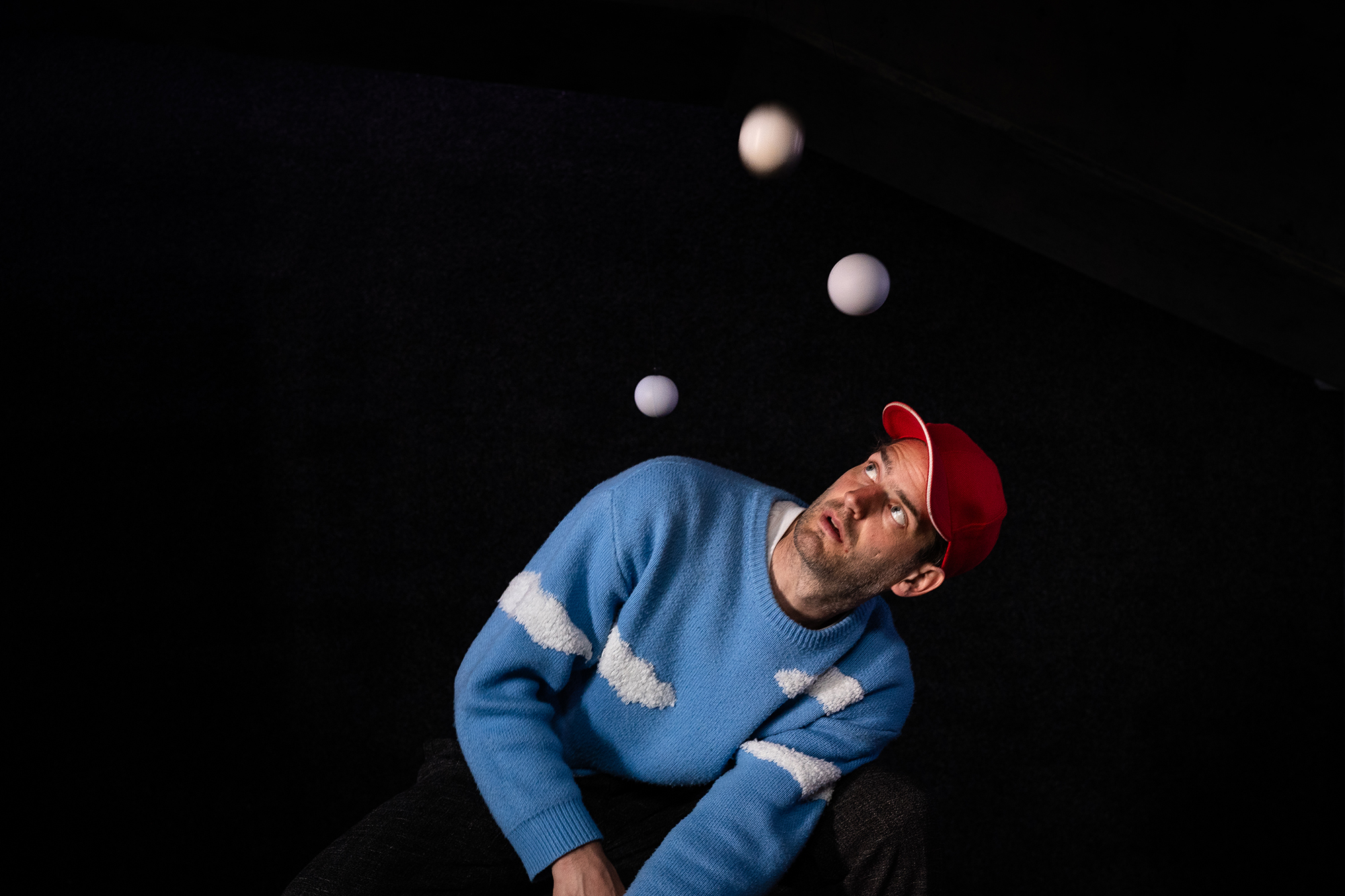 Bälle fliegen um einen Mann herum.