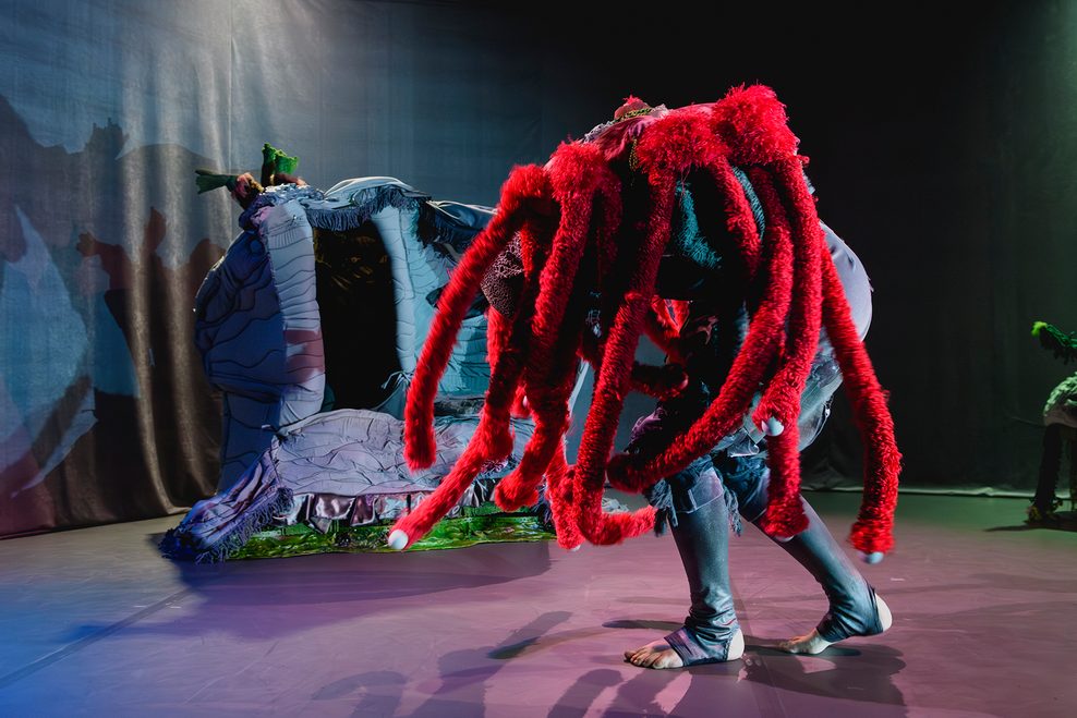 Ein Schauspieler trägt das Kostüm eines Wasserlebewesens.