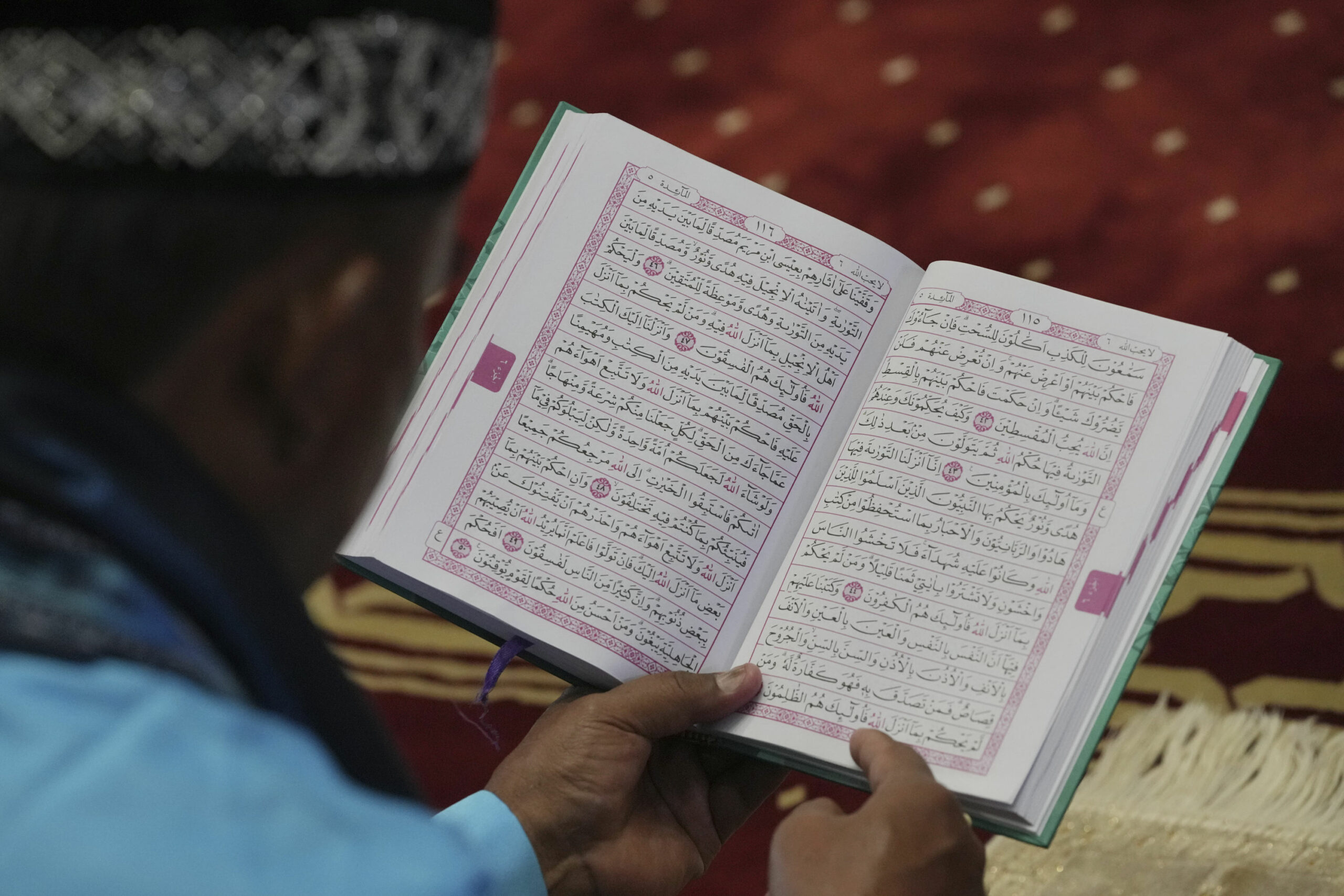 Ein Mann liest in einem Koran (Symbolbild).