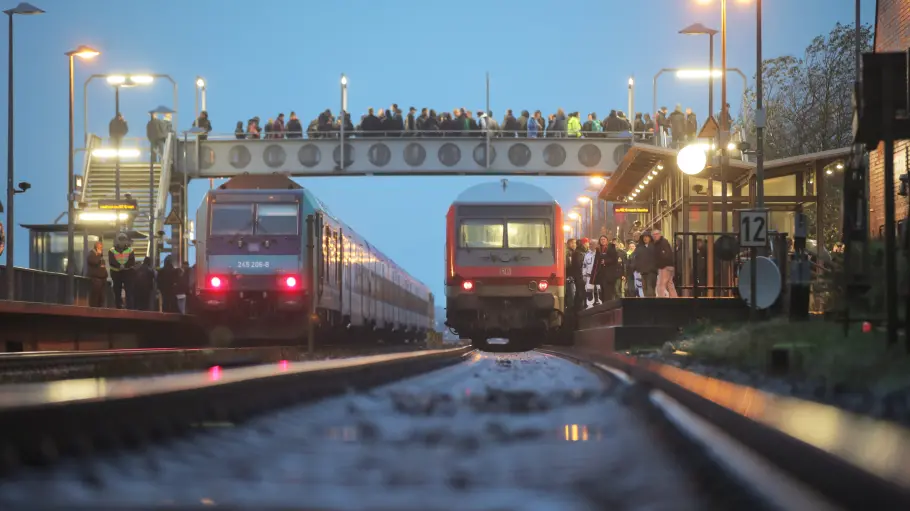 Zwei Züge stehen am Bahnhof.