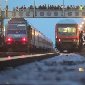Zwei Züge stehen am Bahnhof.