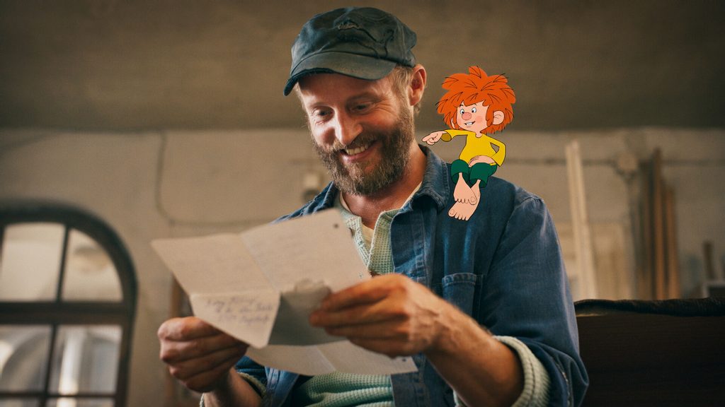 Florian Brückner hält einen Brief in der Hand. Auf seiner Schulter sitzt der Kobold Pumuckl.