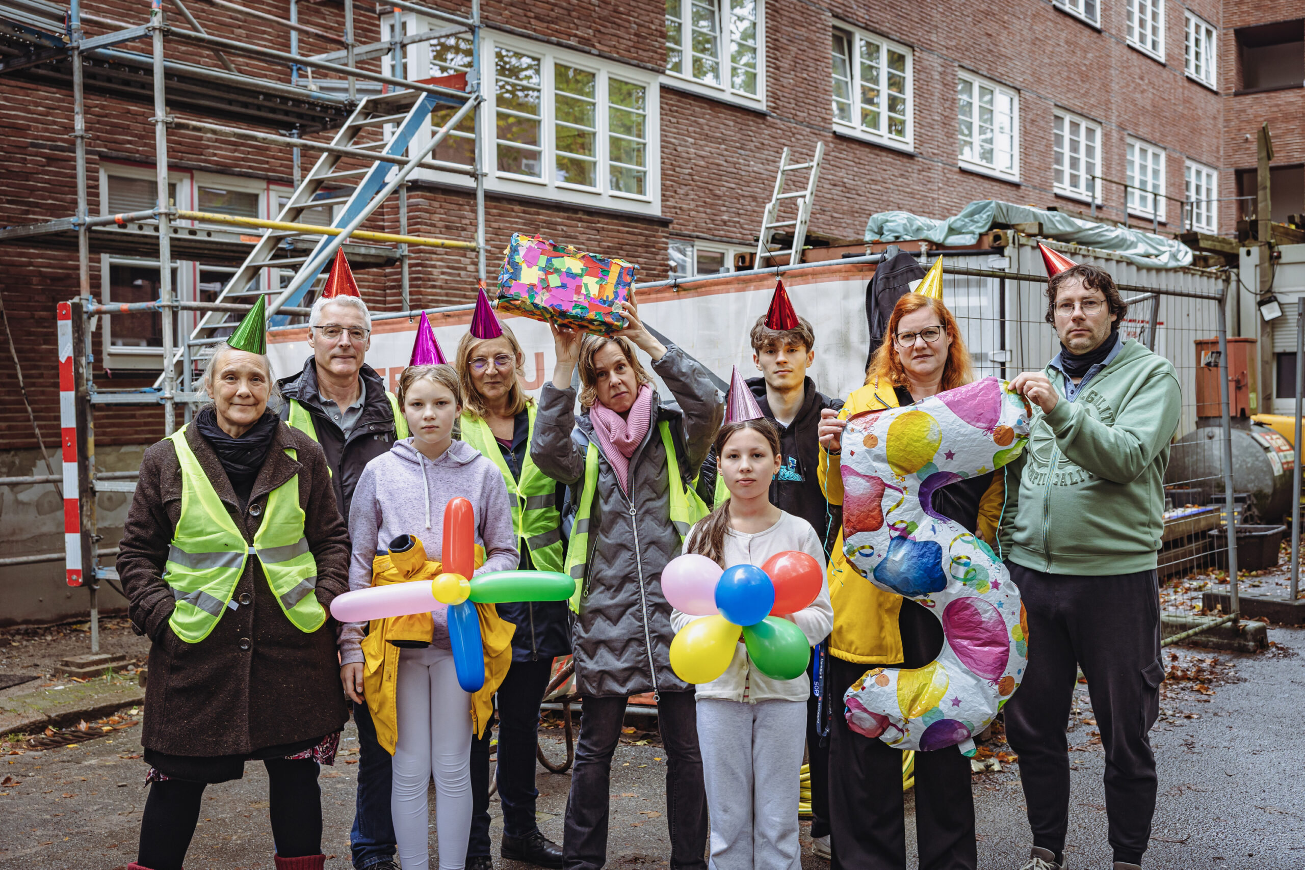 Meike Becker (mit „Geschenk“), Judith Ludwig (2.v.r.) und ihre Nachbarn „feiern“ am Samstag fünf Jahre Baustelle.
