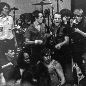Joe Strummer (M.) deutet wütend in die Menge, als Punks die Bühne stürmen wollten. 