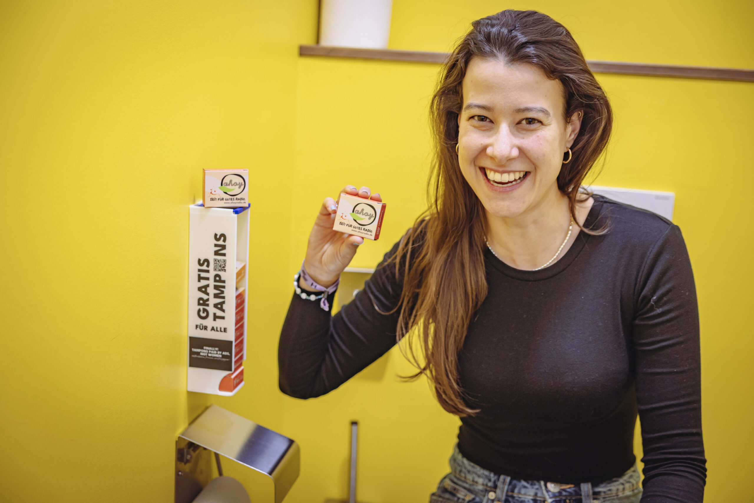 Junge Frau hält lächelnd ein kleines Päckchen