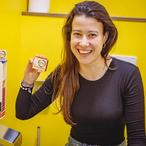 Junge Frau hält lächelnd ein kleines Päckchen