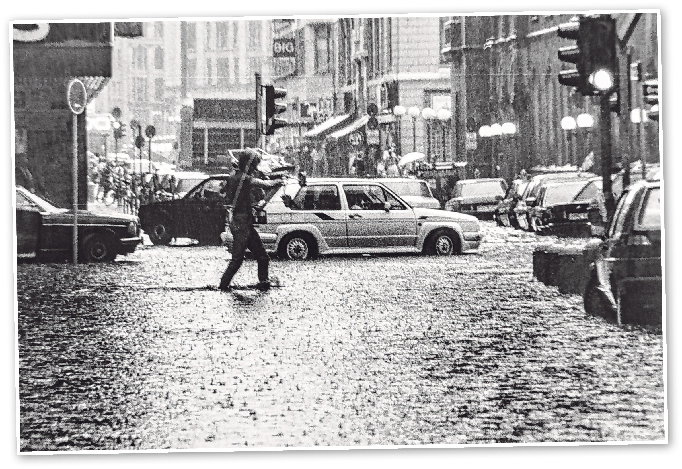 Um 1990 steht die Poststraße unter Wasser. Ein Passant trägt einen Kinderwagen und watet Richtung Große Bleichen.