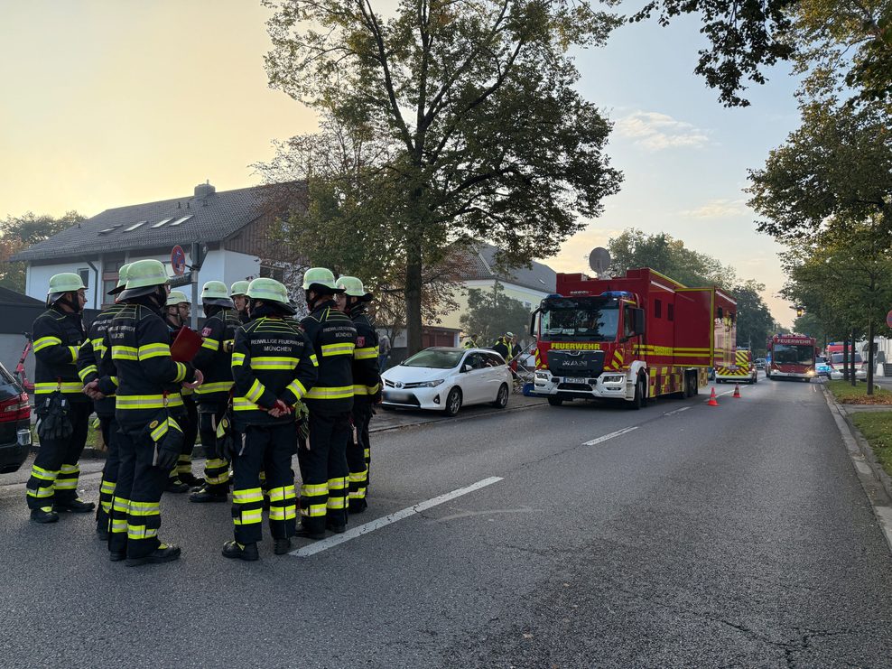 Poliisten und Feuerwehrleute stehen auf einer Straße in München