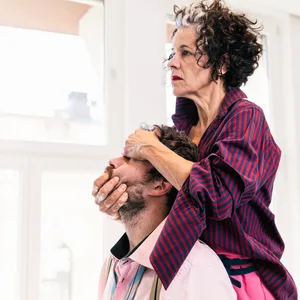 Eine Frau hält den Kopf eines Mannes fest.