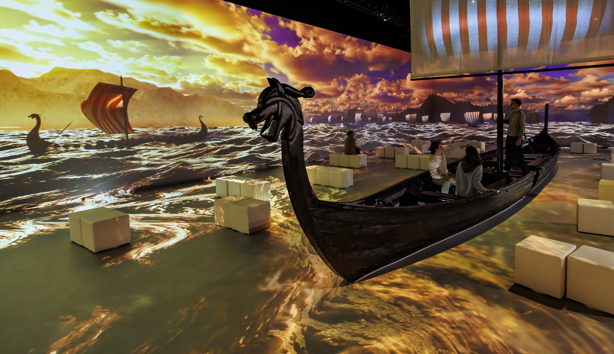 Ein Drachenboot in einer Halle mit Projektionen des Meeres an den Wänden