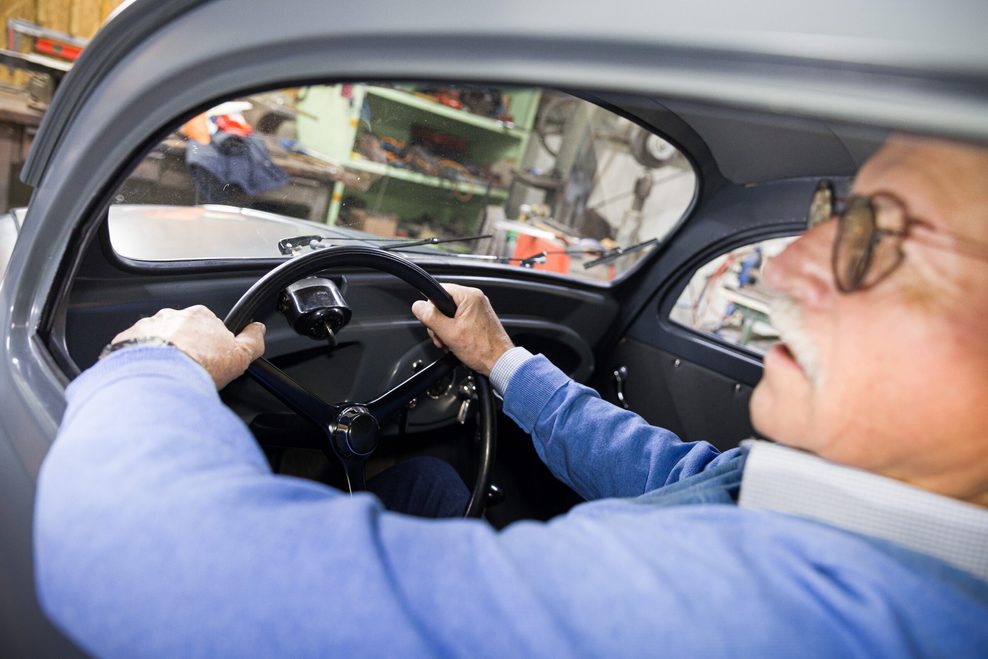 Mann am Steuer von VW Käfer