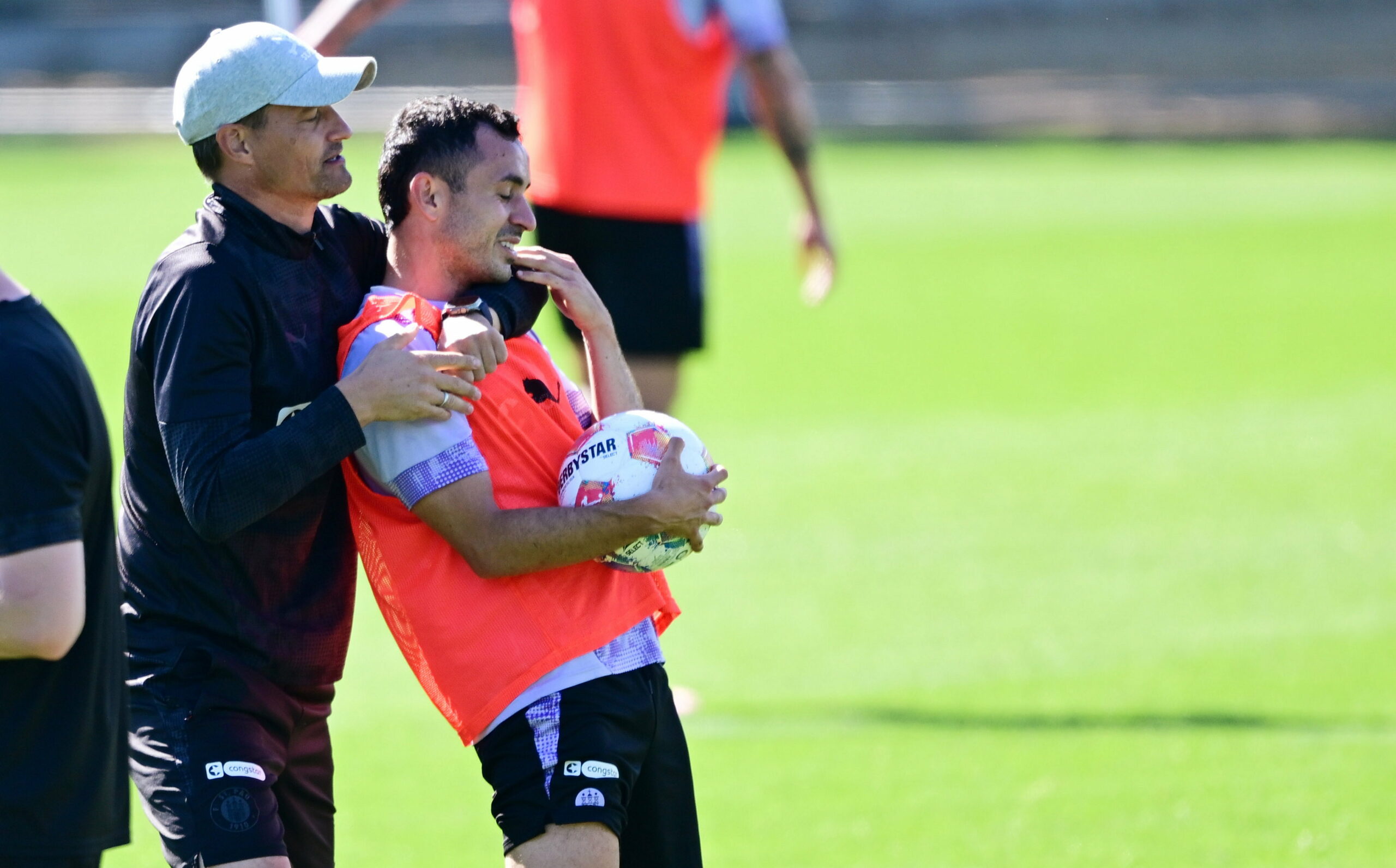 Alexander Blessin umarmt Manolis Saliakas im St. Pauli-Training von hinten.