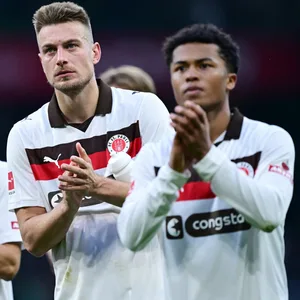 Die St. Pauli-Profis Martijn Kaars, Hauke Wahl und Joel Chima Fujita bedanken sich in Bremen bei den mitgereisten Fans