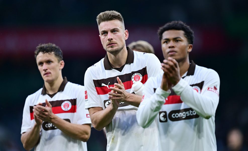 Die St. Pauli-Profis Martijn Kaars, Hauke Wahl und Joel Chima Fujita bedanken sich in Bremen bei den mitgereisten Fans