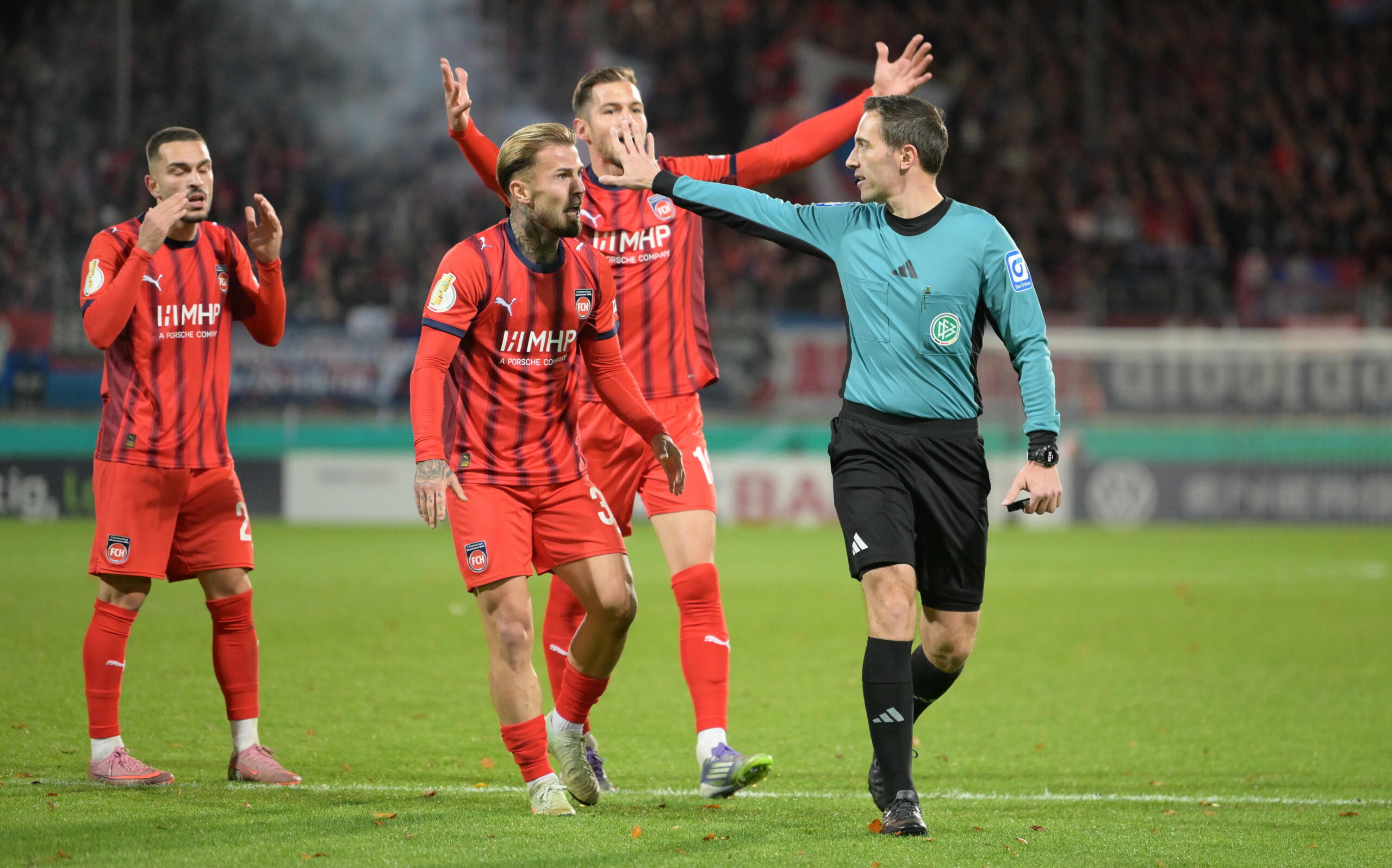 Die Heidenheim-Profis protestieren vor Schiedsrichter Benjamin Brand
