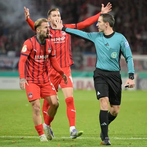 Die Heidenheim-Profis protestieren vor Schiedsrichter Benjamin Brand