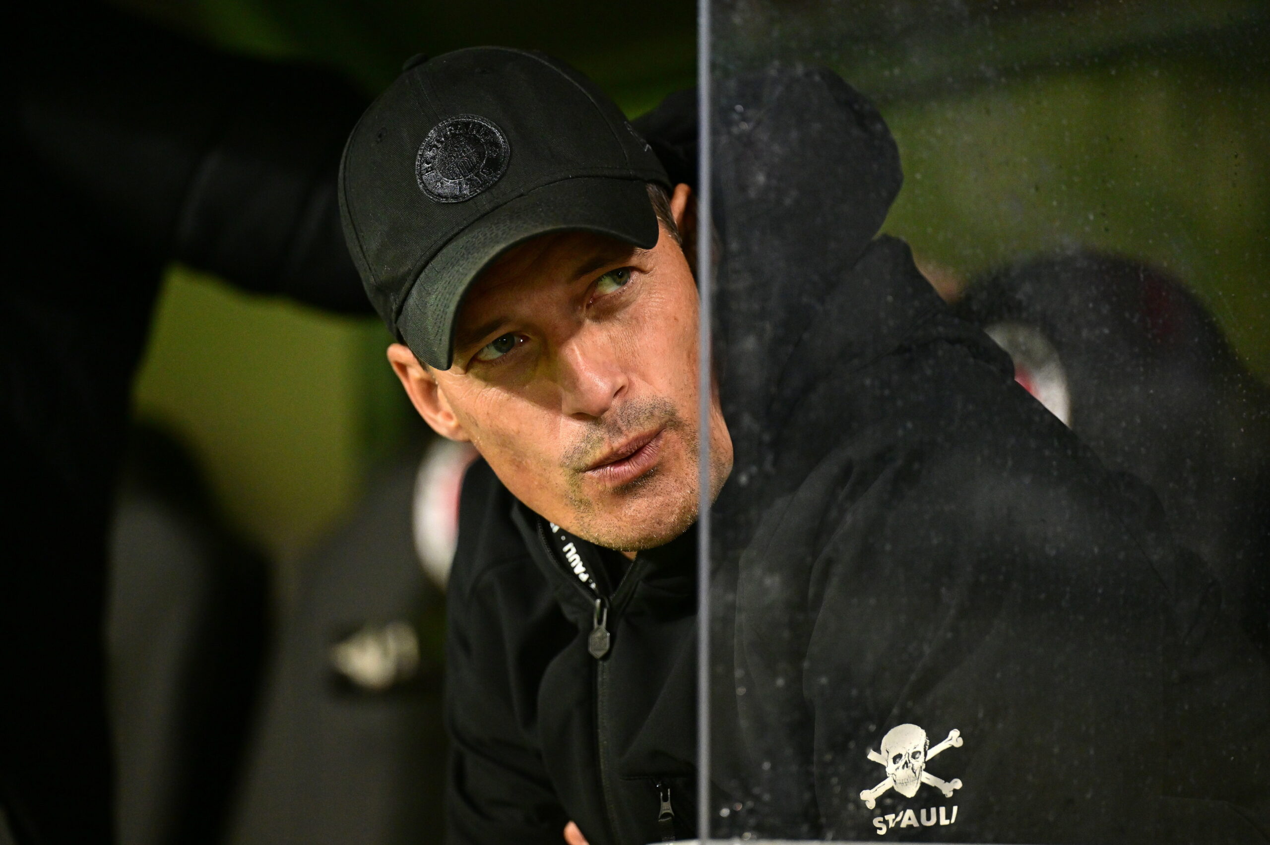 Alexander Blessin auf der Trainerbank zur Seite guckend und die Lippen spitzend