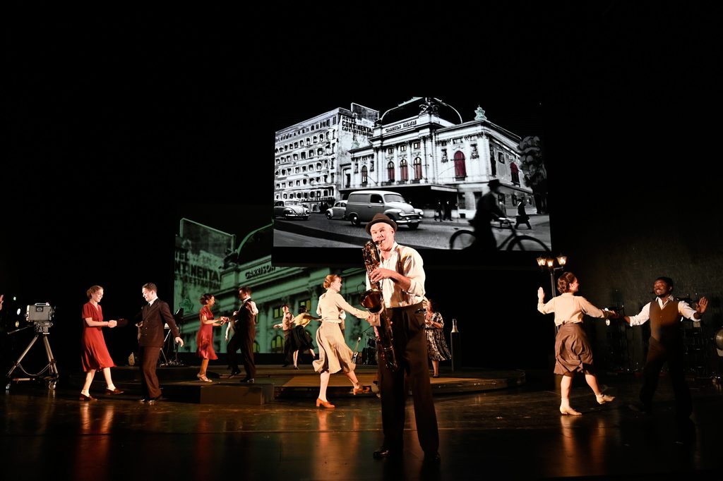 Schauspieler Yorck Dippe und mehrere Tänzer:innen stehen gemeinsam auf der Bühne.