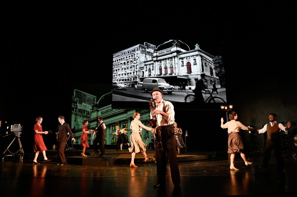 Schauspieler Yorck Dippe und mehrere Tänzer:innen stehen gemeinsam auf der Bühne.