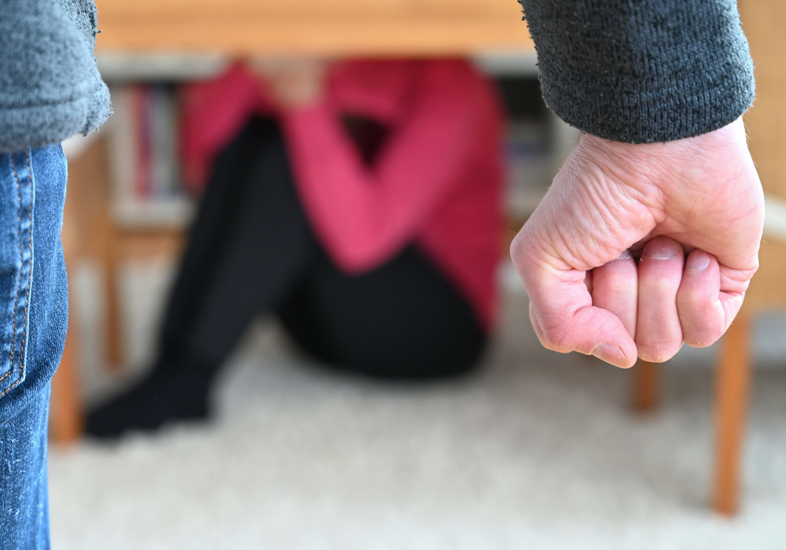 Eine Frau versucht, sich vor der Gewalt eines Mannes zu schützen.