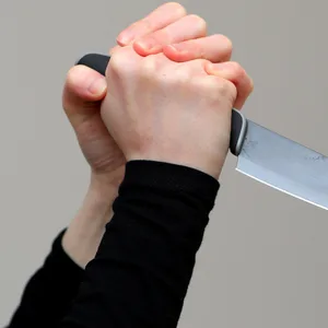 Eine Hand hält ein gefährliches Messer in der Hand.