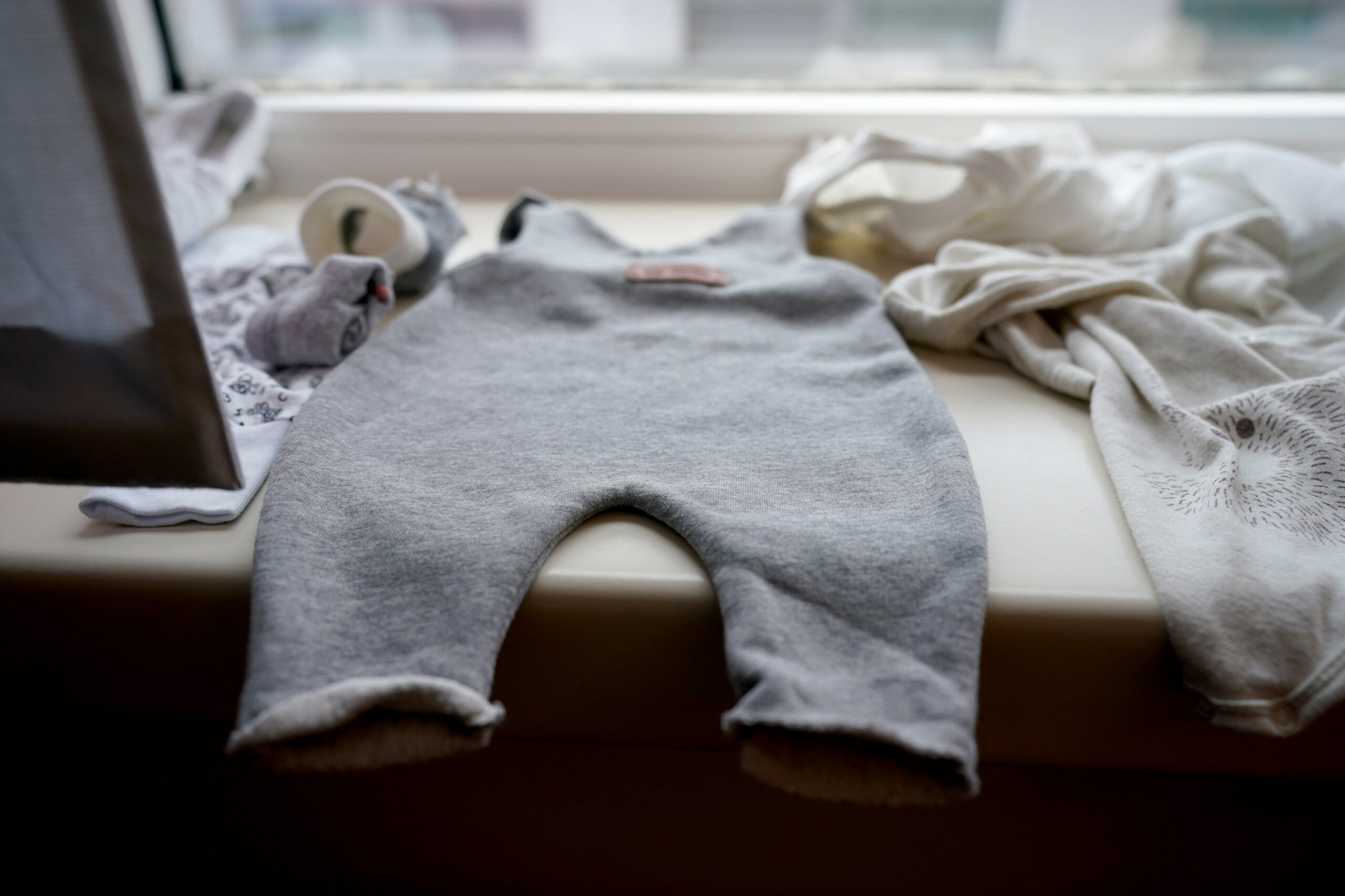 Ein Strampler liegt auf der Fensterbank einer Geburtshilfestation im Krankenhaus.