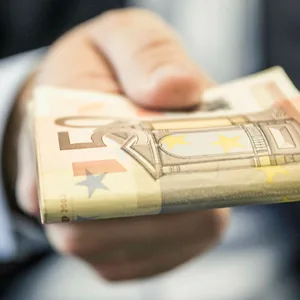 Eine Hand bietet Geldscheine an.