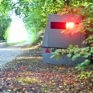 Eine Blitzeranhänger steht versteckt am Straßenrand (Symbolbild).