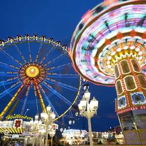 Hamburger Winterdom mit bunt beleuchtetem Riesenrad und Fahrgeschäft