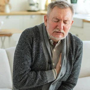 Ein älterer Mann hat Schmerzen am Herzen.