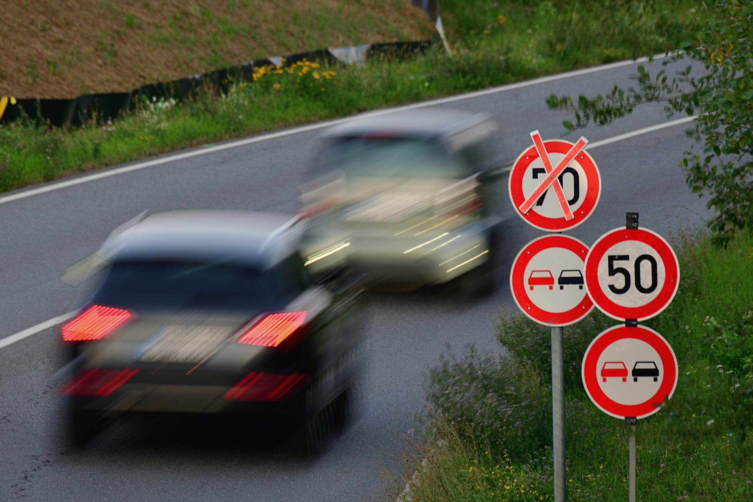 Schnell fahrende Autos auf einer Straße mit einer zugelassen Höchstgeschwindigkeit von 50 kmh.