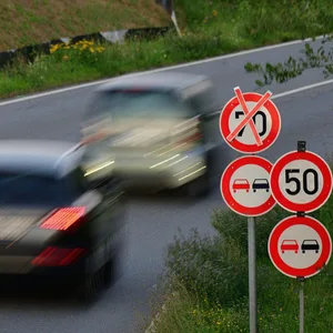 Schnell fahrende Autos auf einer Straße mit einer zugelassen Höchstgeschwindigkeit von 50 kmh.