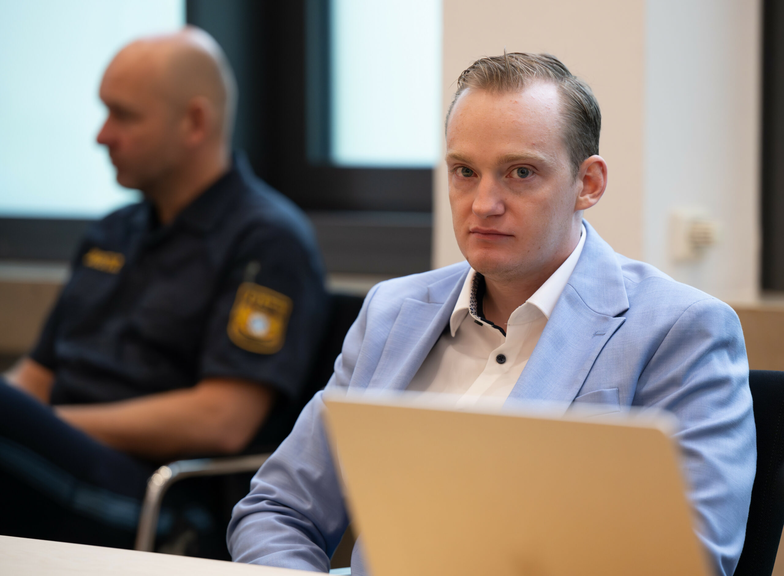 Der Angeklagte (r) sitzt im Amtsgericht im Sitzungssaal.