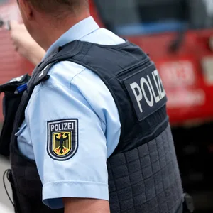 Ein Bundespolizist vor einer Regionalbahn im Bahnhof