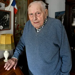 Charles Coste posiert vor seinen zahlreichen Auszeichnungen