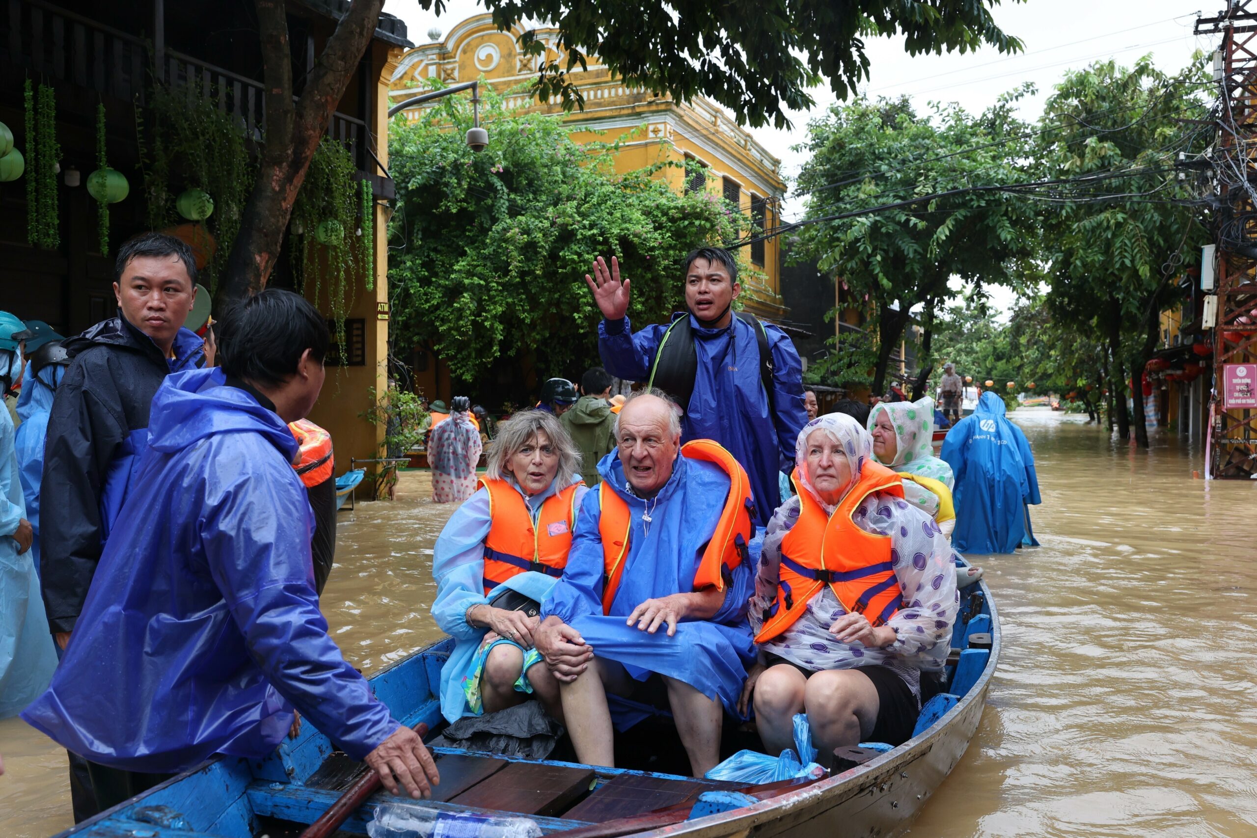 Touristen werden mit einem Boot aus den Fluten evakuiert.