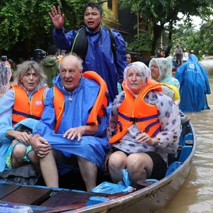 Touristen werden mit einem Boot aus den Fluten evakuiert.