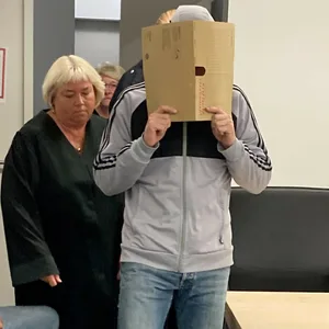 Der Angeklagte kommt mit Fußfesseln neben seiner Verteidigerin in den Gerichtssaal im Landgericht zum Prozess wegen sexuellen Missbrauchs