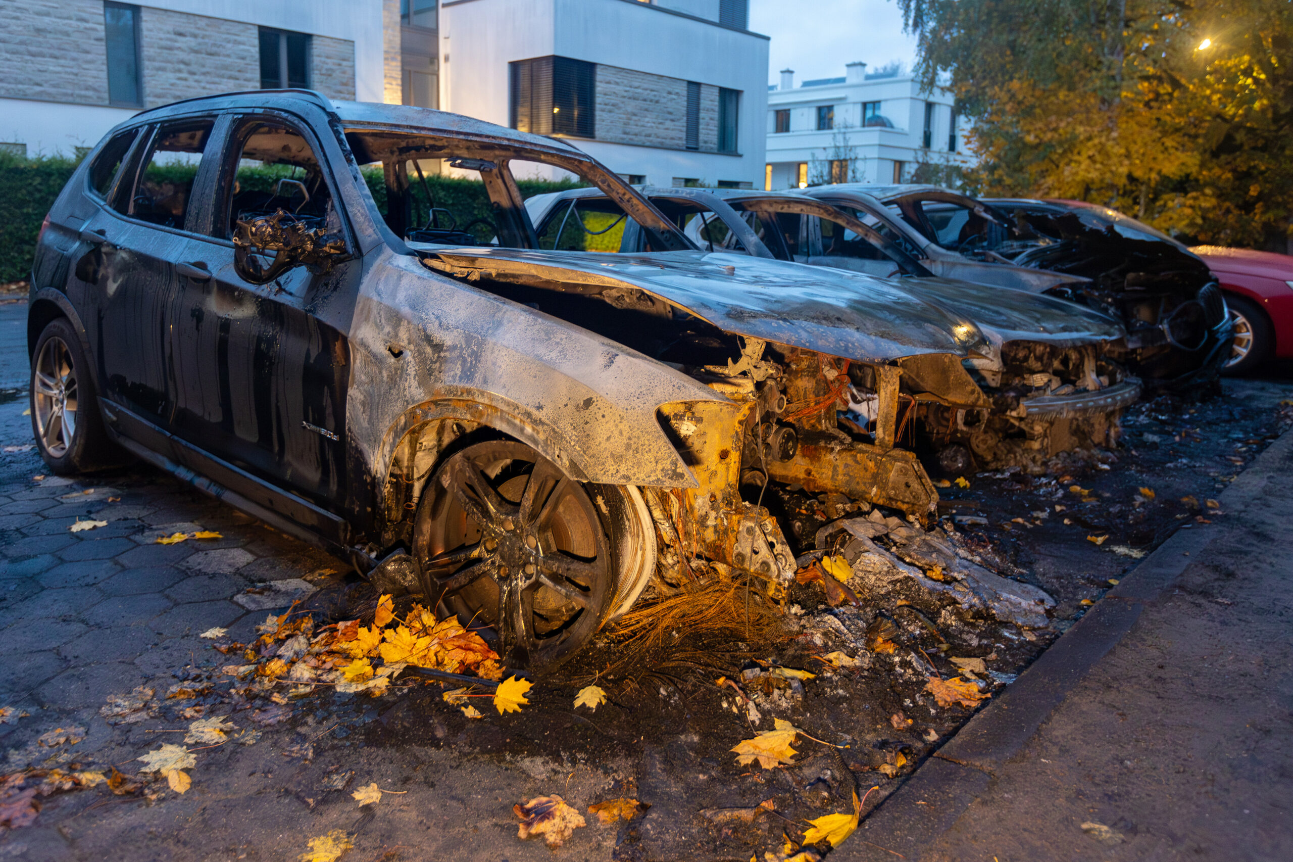 Ausgebrannte Fahrzeuge stehen im Stadtteil Othmarschen im Hamburger Westen an einer Strasse.