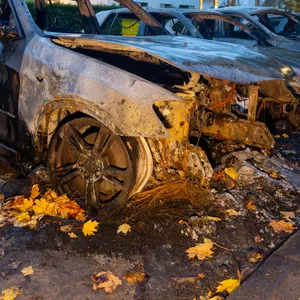 Ausgebrannte Fahrzeuge stehen im Stadtteil Othmarschen im Hamburger Westen an einer Strasse.