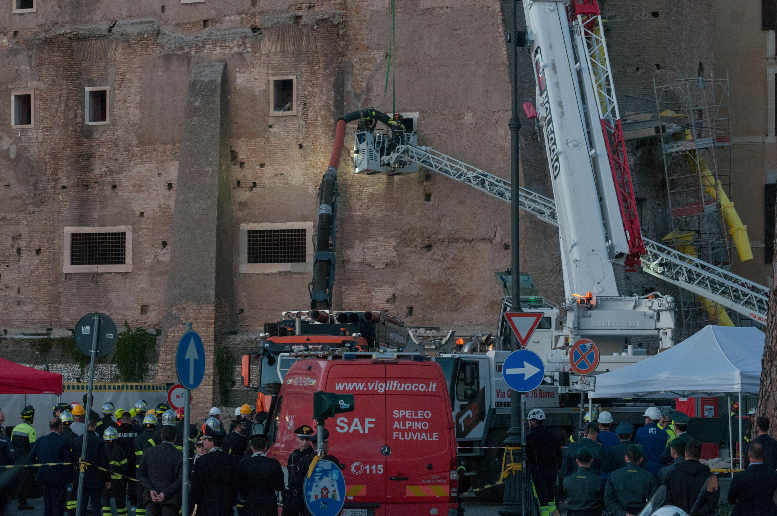 Feuerwehrleute ziehen einen Bauarbeiter aus den Trümmern eines mittelalterlichen Turms