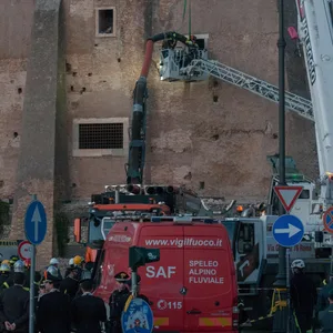 Feuerwehrleute ziehen einen Bauarbeiter aus den Trümmern eines mittelalterlichen Turms