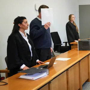 Stefan Becker (3.v.r), Vorsitzender Richter, der Angeklagte (2.v.l), seine Anwältin Gülbahar Kisin (l) und weitere Prozessbeteiligte stehen im Gerichtssaal zu Beginn eines Prozesses vor dem Landgericht. Am Donnerstag begann der Prozess gegen den 39-Jährigen wegen Totschlags.