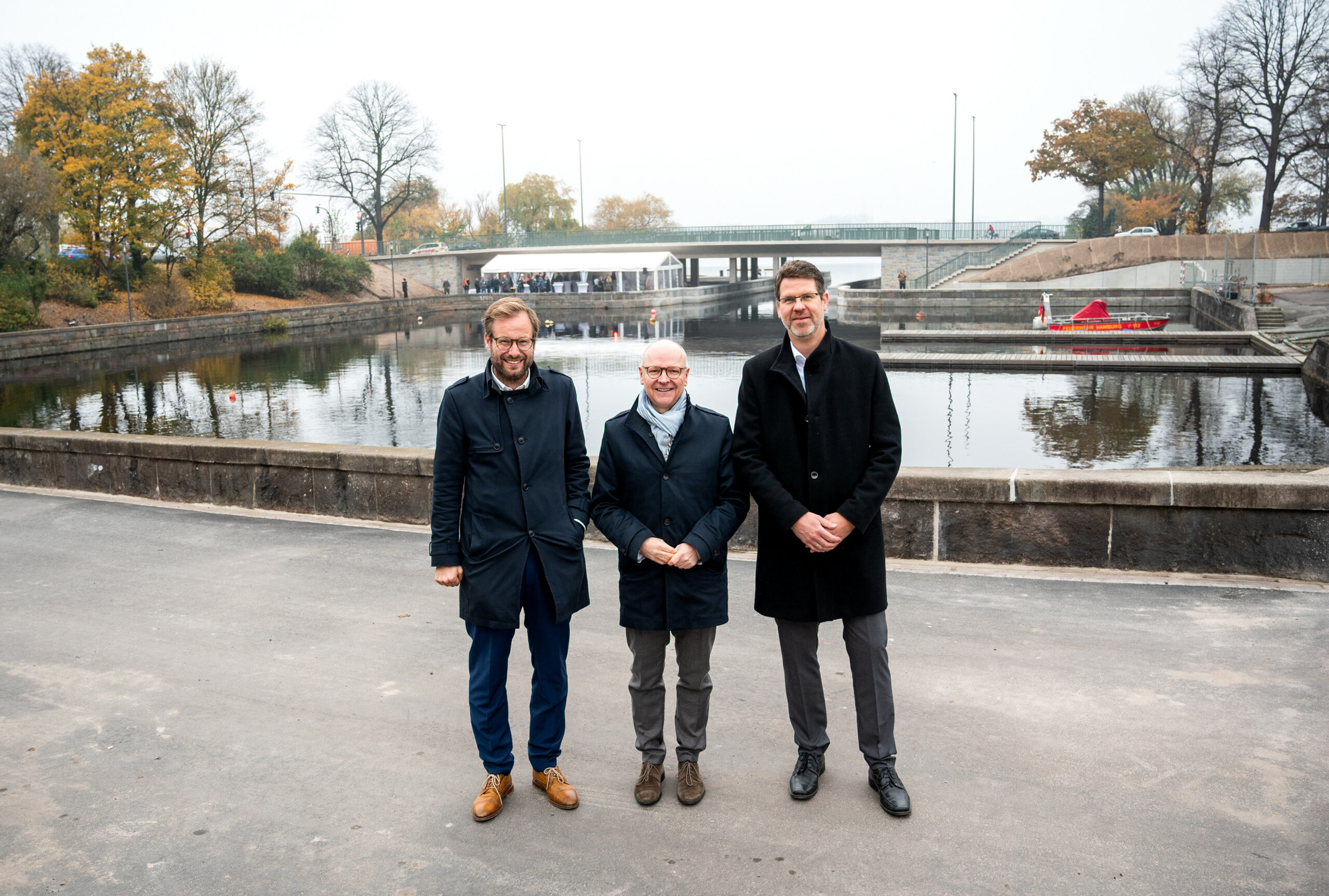Verkehrssenator Anjes Tjarks (Grüne, v. l.), Stefan Klotz, Geschäftsführer des Landesbetriebs Straßen, Brücken und Gewässer (LSBG), und Björn Mardfeldt, LSBG-Geschäftsbereichsleiter konstruktive Ingenieurbauwerke, stehen an der umgestalteten Hohenfelder Bucht.