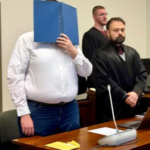 Der 26-jährige Angeklagte steht im Gerichtssaal neben seinem Verteidiger.