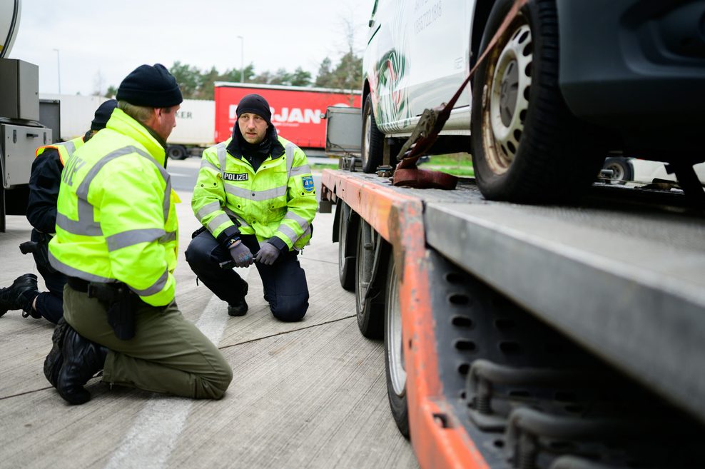 Beamte kontrollieren die Ladung sowie die Sicherung eines Lkws.